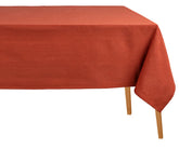 Rust-colored rectangular cotton tablecloth on a dining table, soft and durable fabric, perfect for everyday meals, festive holidays, weddings, or restaurant use.