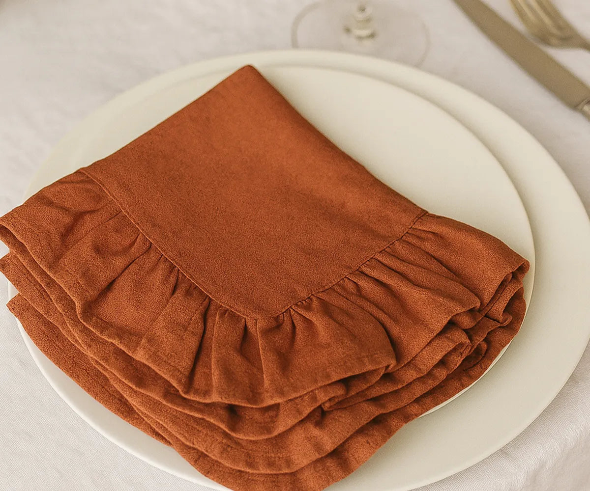 Set of 100% cotton rust-colored ruffled napkins, eco-friendly and washable fabric dinner napkins available in bulk or small sets, perfect for casual meals and elegant celebrations.