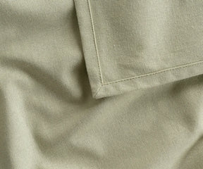 Soft, breathable sage green cotton tablecloth in multiple sizes, offering a timeless, eco-friendly alternative to disposable or polyester options.