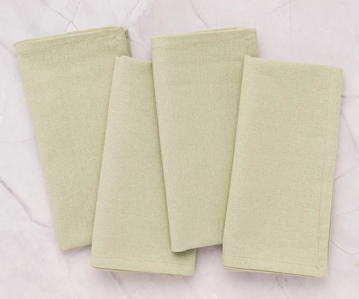 Wedding reception table decorated with sage green cotton napkins, offering a sustainable, elegant, and eco-friendly table linen option