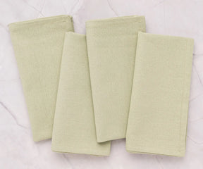 Wedding reception table decorated with sage green cotton napkins, offering a sustainable, elegant, and eco-friendly table linen option