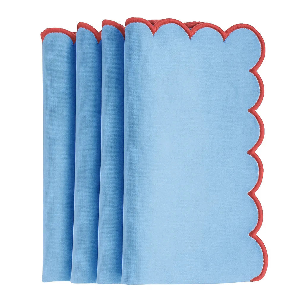 Blue scalloped edge cotton dinner napkins neatly folded on a dining table with matching placemats – set of 12