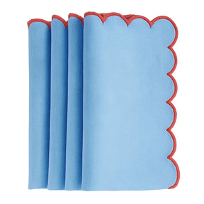 Blue scalloped edge cotton dinner napkins neatly folded on a dining table with matching placemats – set of 12