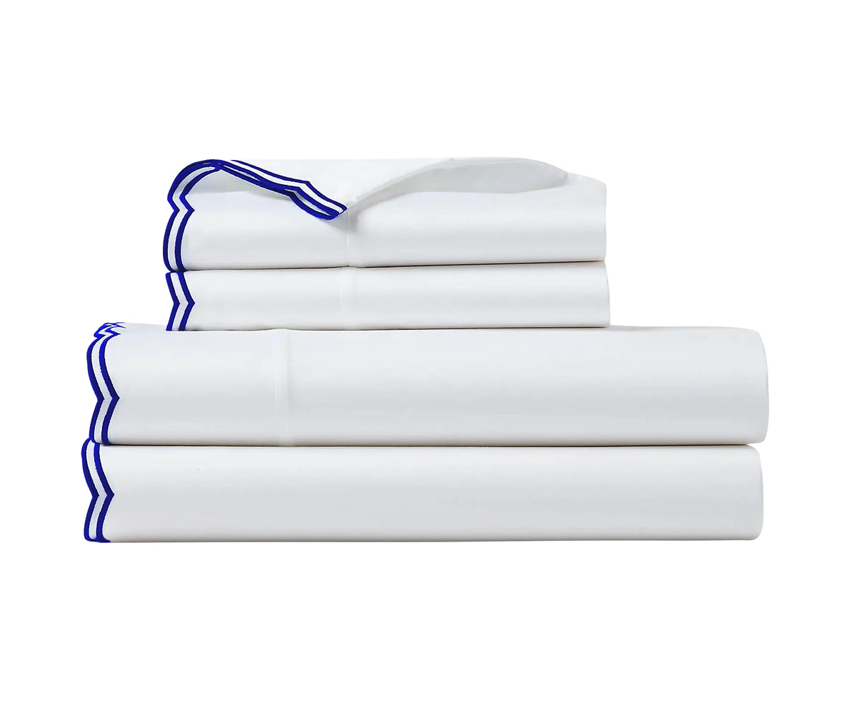 Blue scalloped edge sheet set in 100% cotton displayed on a neatly made bed in a modern bedroom – available in King, Queen, and Twin sizes