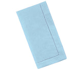 Stack of neatly folded sky blue linen napkins with hemstitched borders on a rustic wooden table