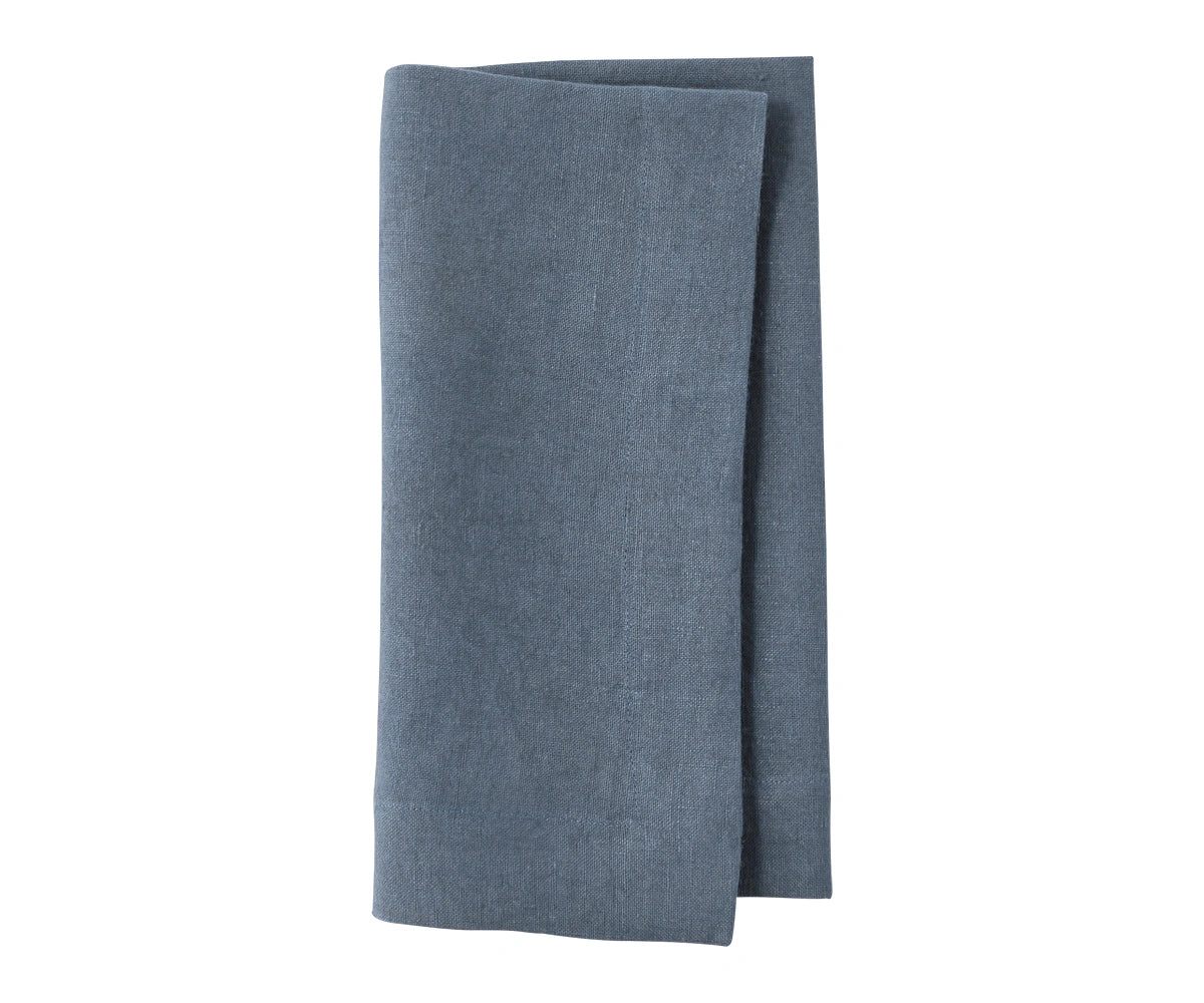 Steel blue plain linen napkin with soft muted tone, placed on dining table