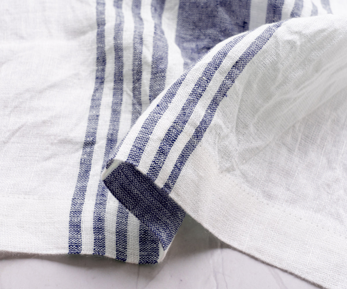 Close-up view of a linen dinner napkin with blue and white stripes