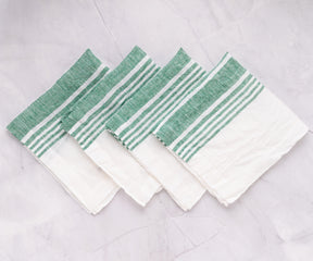 Collection of green-striped linen napkins arranged on marble