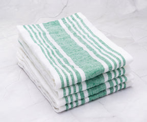 A quartet of linen dinner napkins with green and white stripes neatly stacked