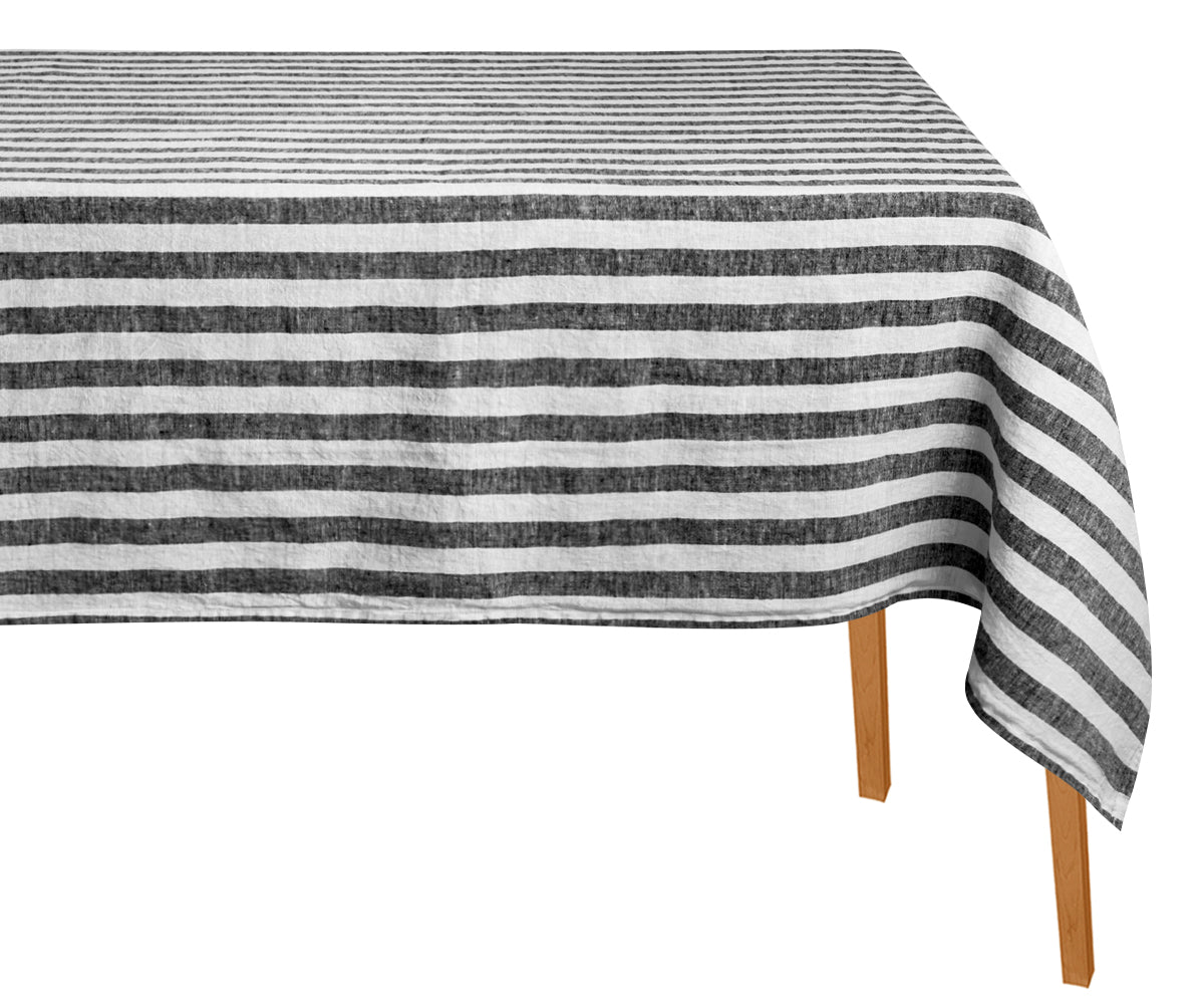 Striped tablecloth with black and white stripes on a wooden table.