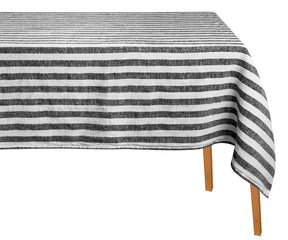 Striped tablecloth with black and white stripes on a wooden table.