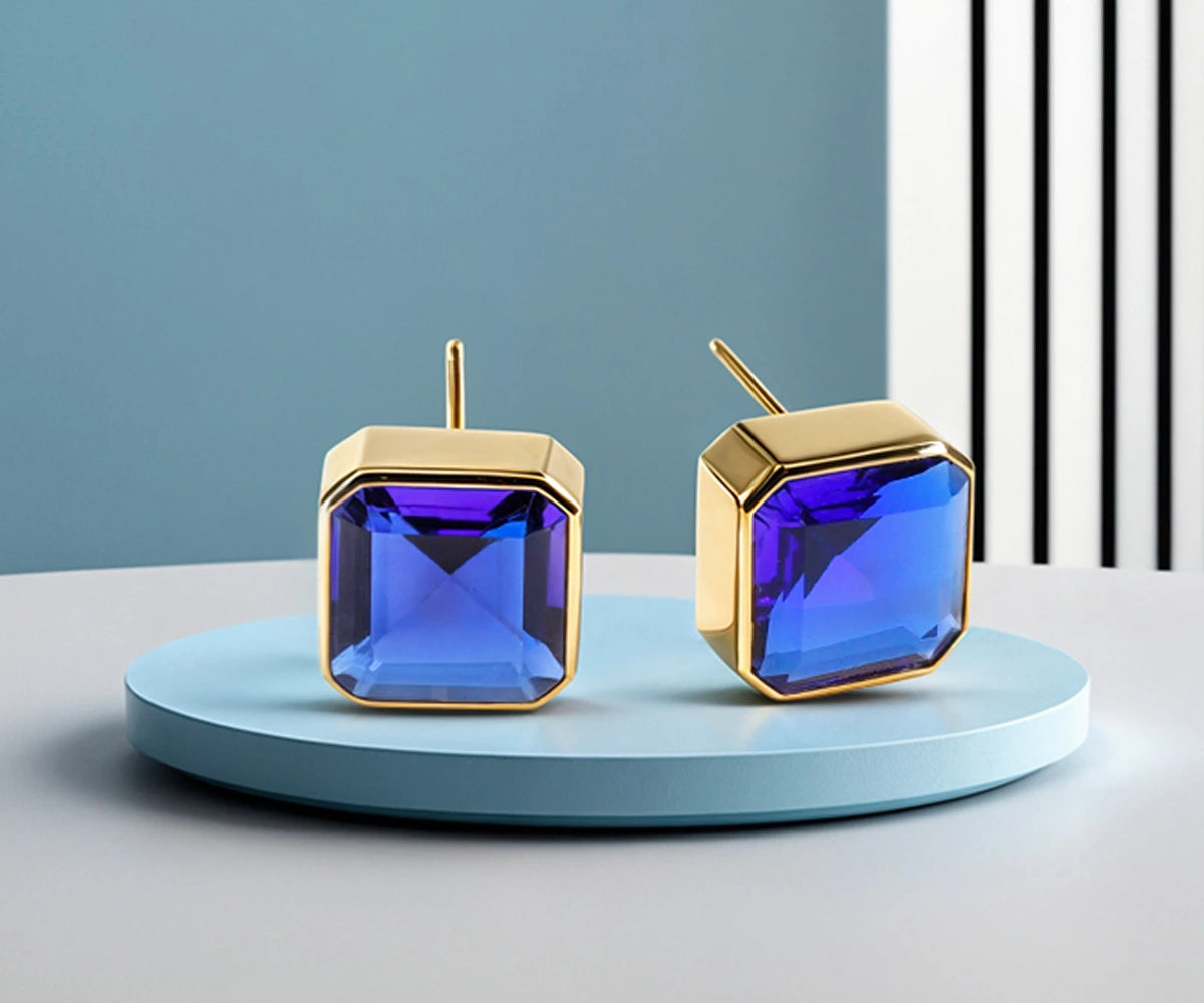 Classic sapphire-inspired stud earrings for women in gold plated brass, featuring a brilliant blue gemstone and timeless minimalist design.