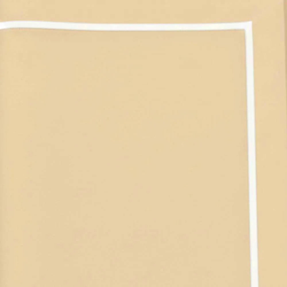 :
Close up of white embroidered details on gold cotton tablecloth