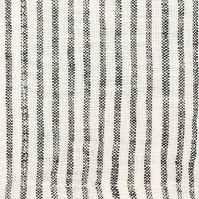 Stack of black and white linen kitchen towels beside fresh bread and cutlery