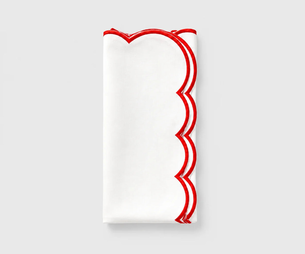 White and red scalloped cloth napkin folded on a white background