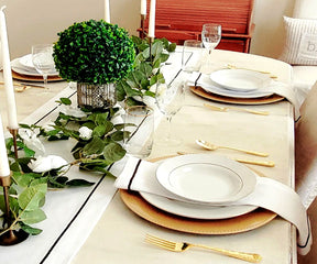 White cotton table runner featuring intricate line embroidery.