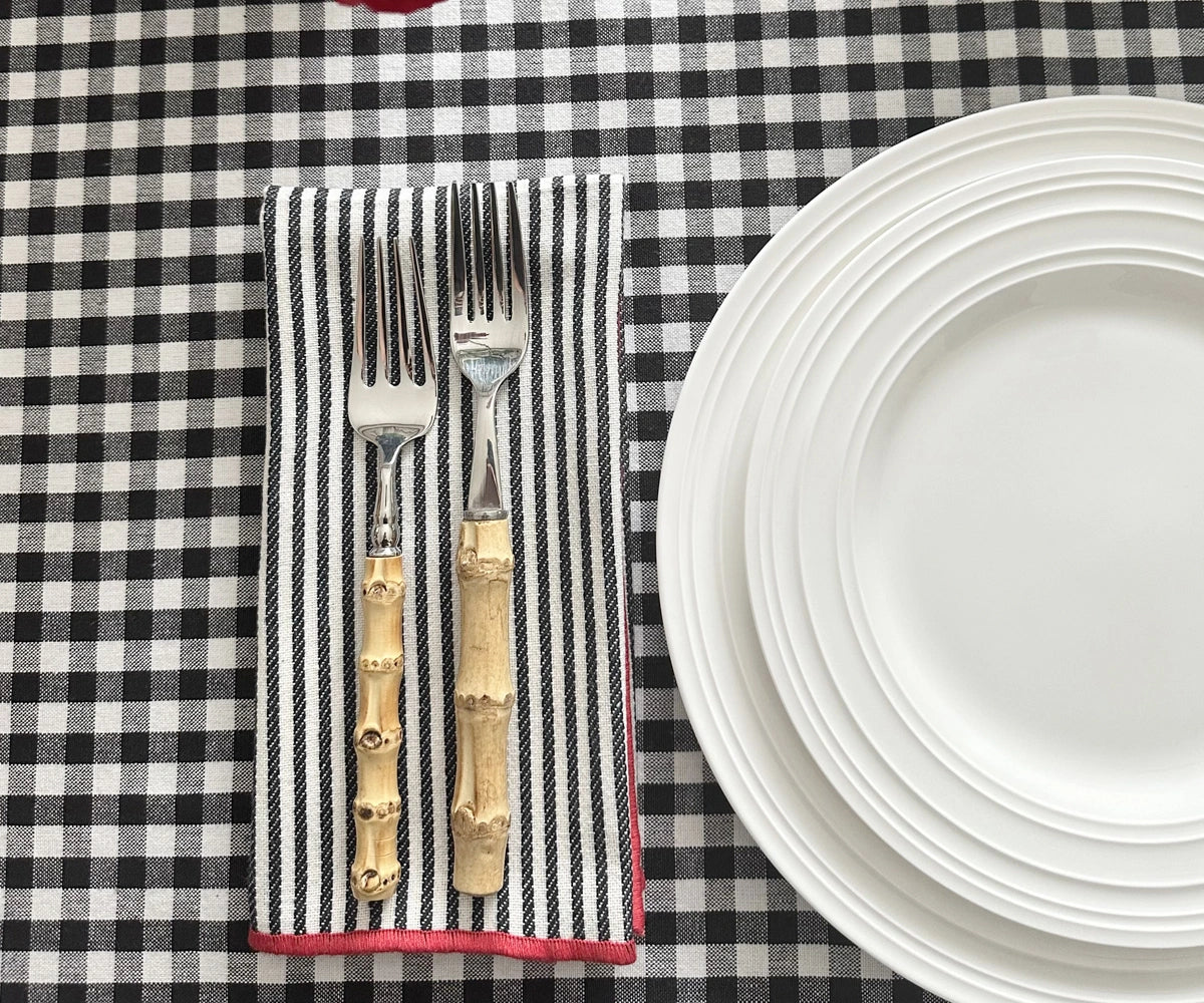 Black and red striped cloth napkins adding contrast to a festive table décor setup.