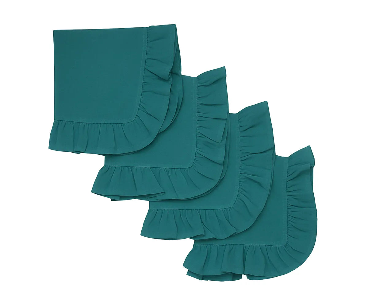 Teal ruffle edge cotton napkins neatly folded on a dining table