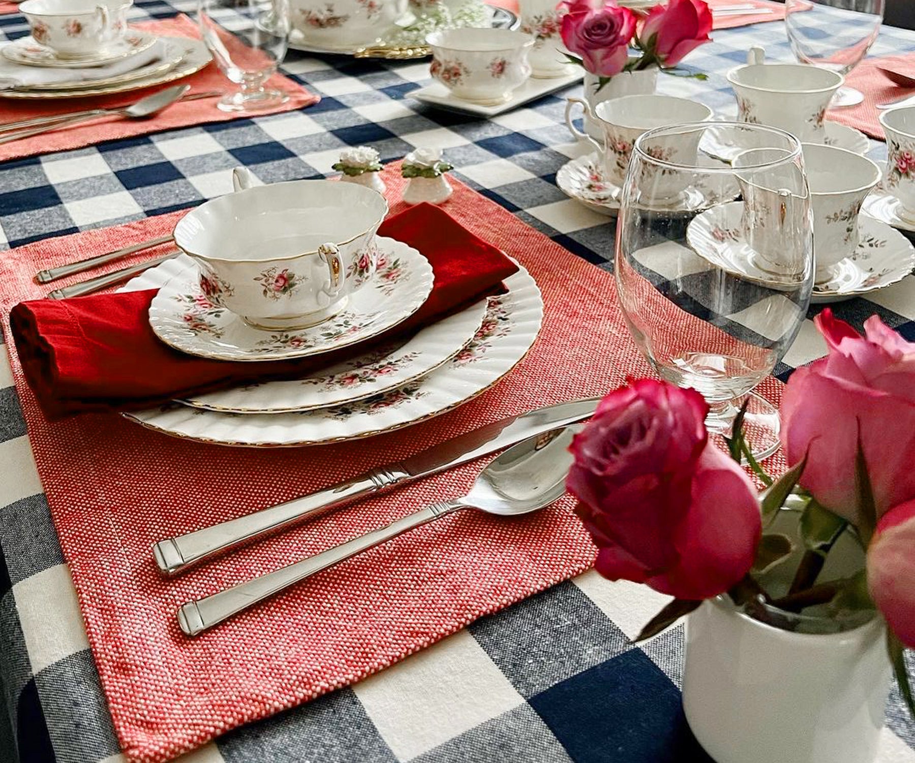 Enhance your dining table with vibrant red fabric placemats, combining elegance and protection for a delightful mealtime ambiance.