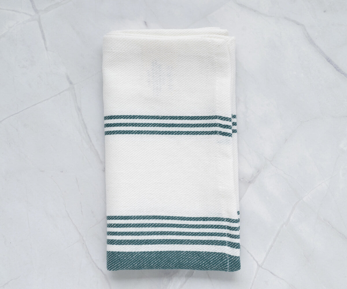 Green and white napkins with a subtle pattern, blending well with rustic table settings.