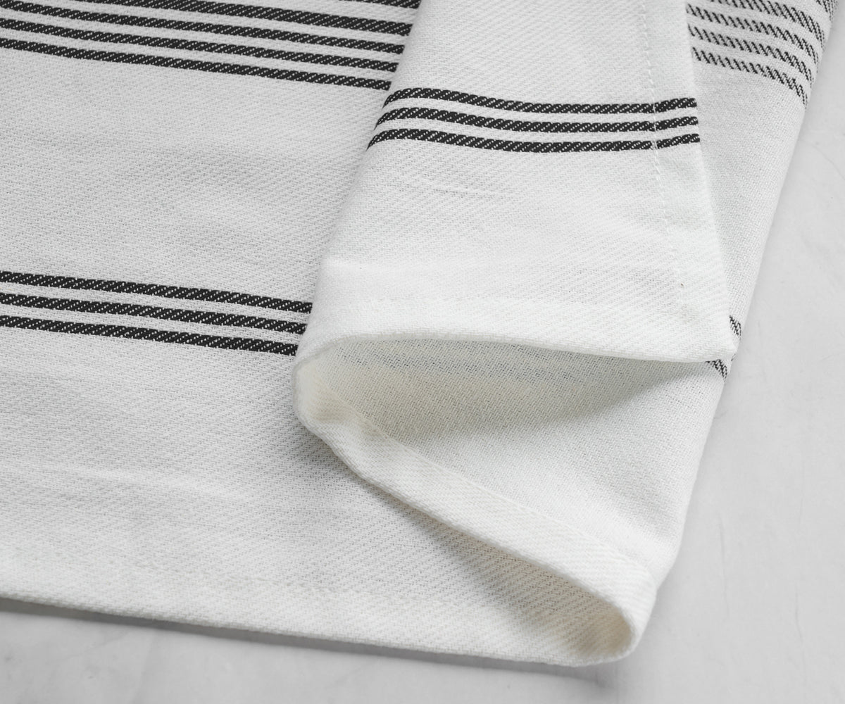 One black striped napkin laid out on a marble background