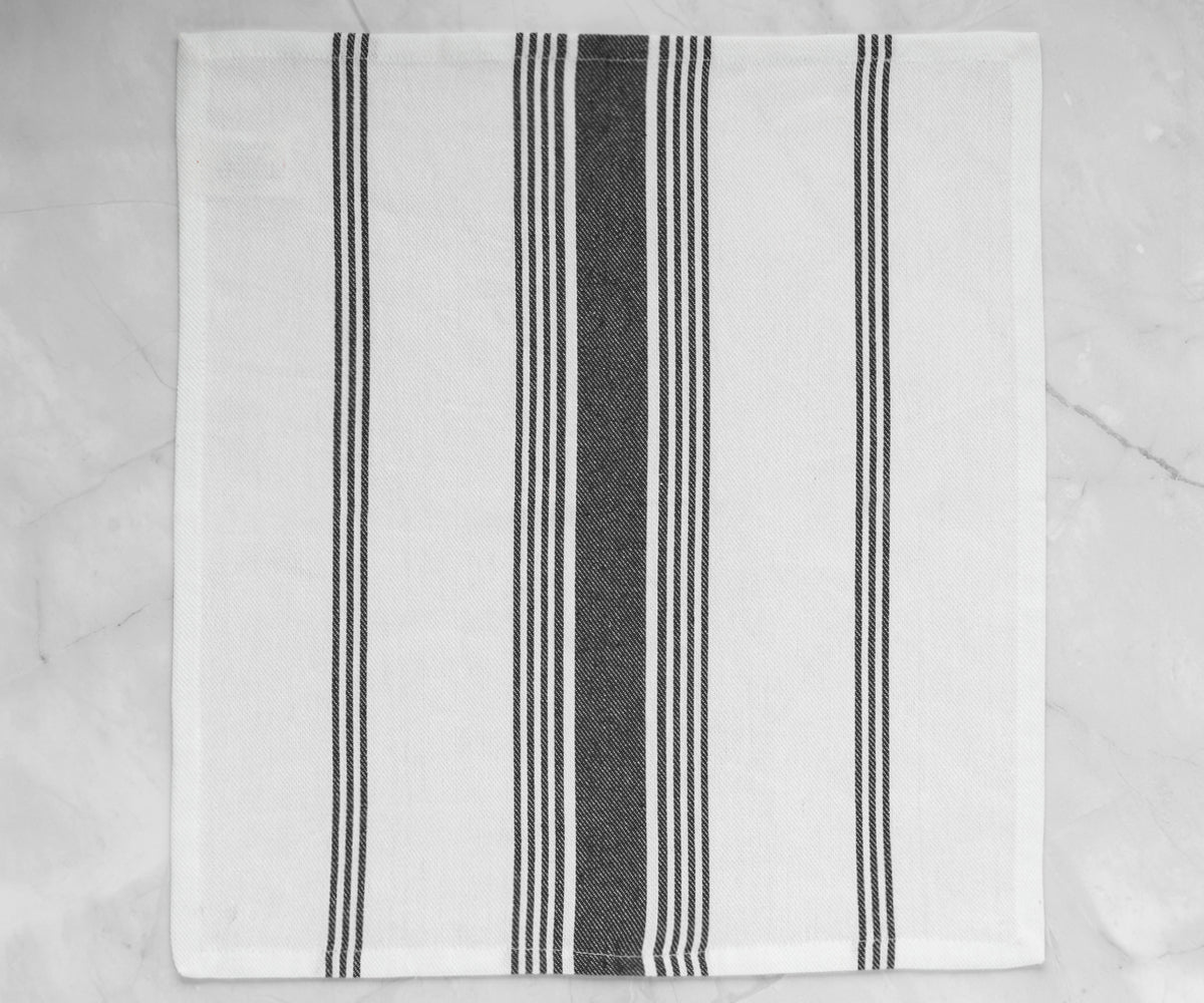 A black and white striped napkin displayed on a marble surface