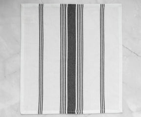 A black and white striped napkin displayed on a marble surface