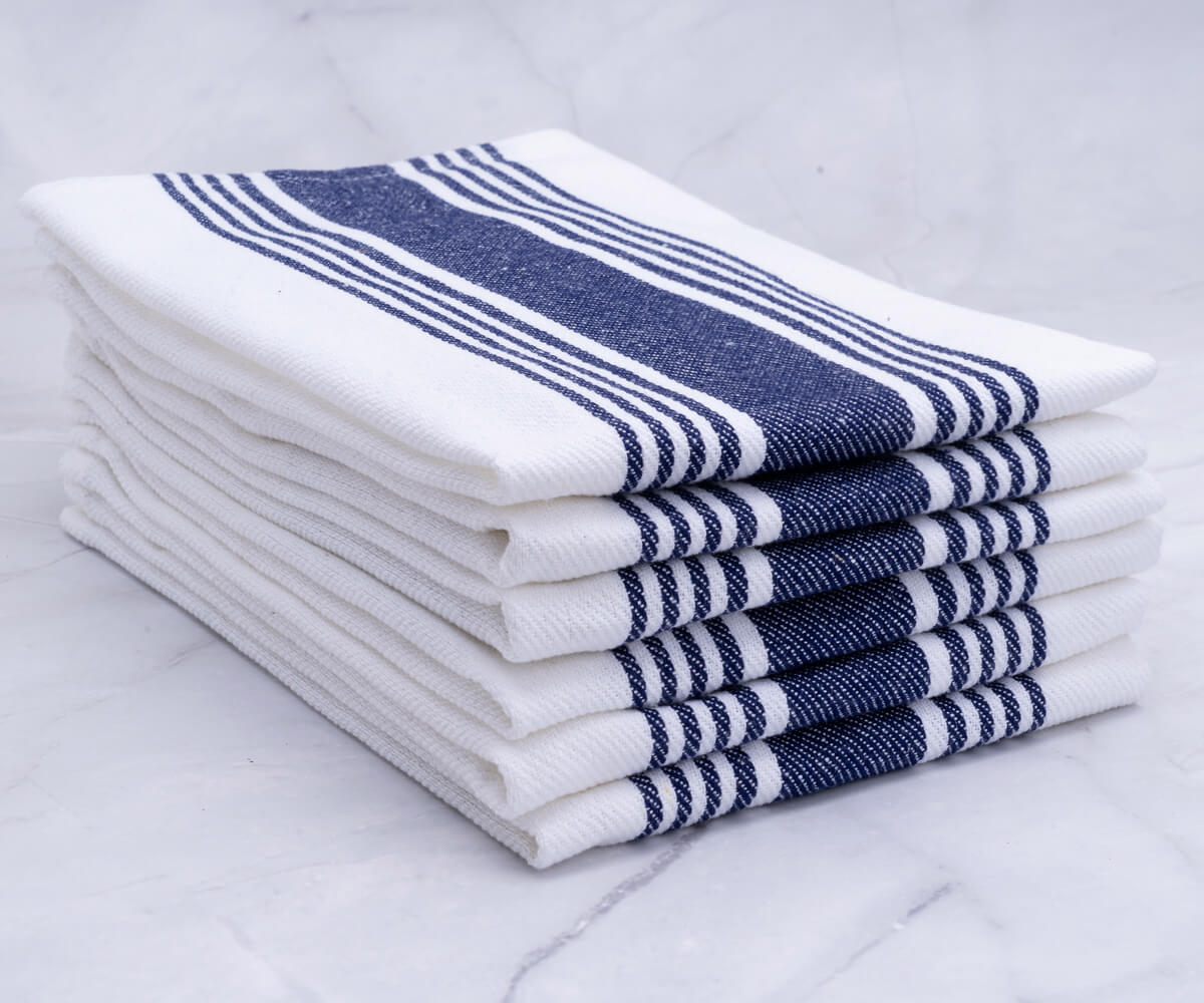 A stack of navy blue napkins, both cloth and cotton, neatly folded.
