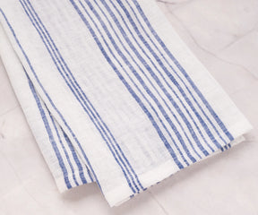 White towel with blue stripe neatly draped over oven handle