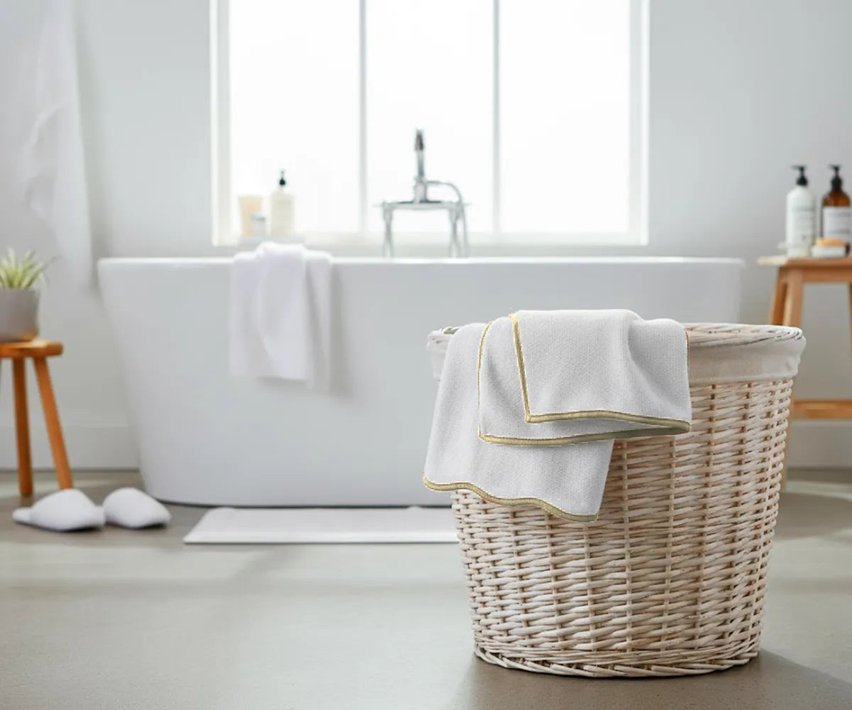 Stack of thick white cotton towels with beige border, ideal for bathroom or spa use
