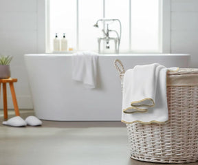 White bath towel with beige edge hanging on a modern bathroom rack
