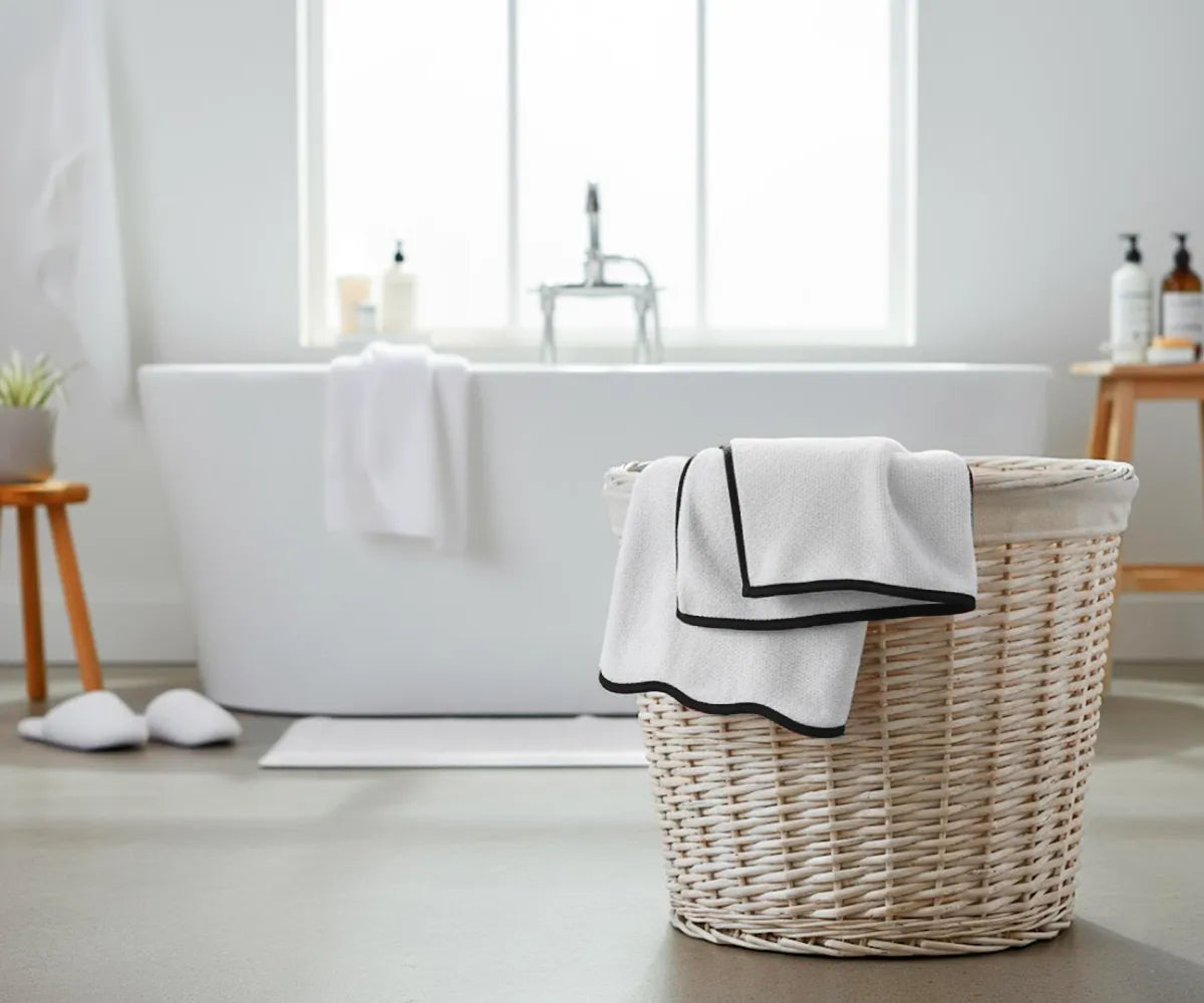 Elegant black and white bath towel featuring a crisp white base with contrasting black border, designed to stay plush and quick-drying after multiple washes.