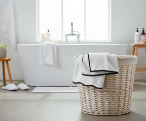 Elegant black and white bath towel featuring a crisp white base with contrasting black border, designed to stay plush and quick-drying after multiple washes.