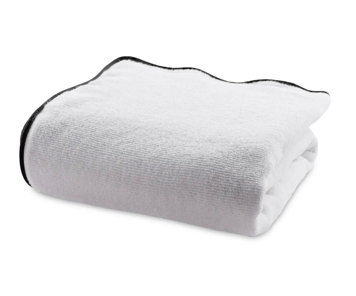 Premium quality white bath towel with refined black edge detailing, made from ultra-absorbent 100% cotton for a modern and sophisticated bathroom look.