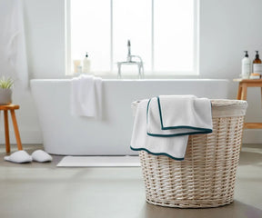 Stack of thick white cotton towels with green trim, perfect for bathroom or spa use