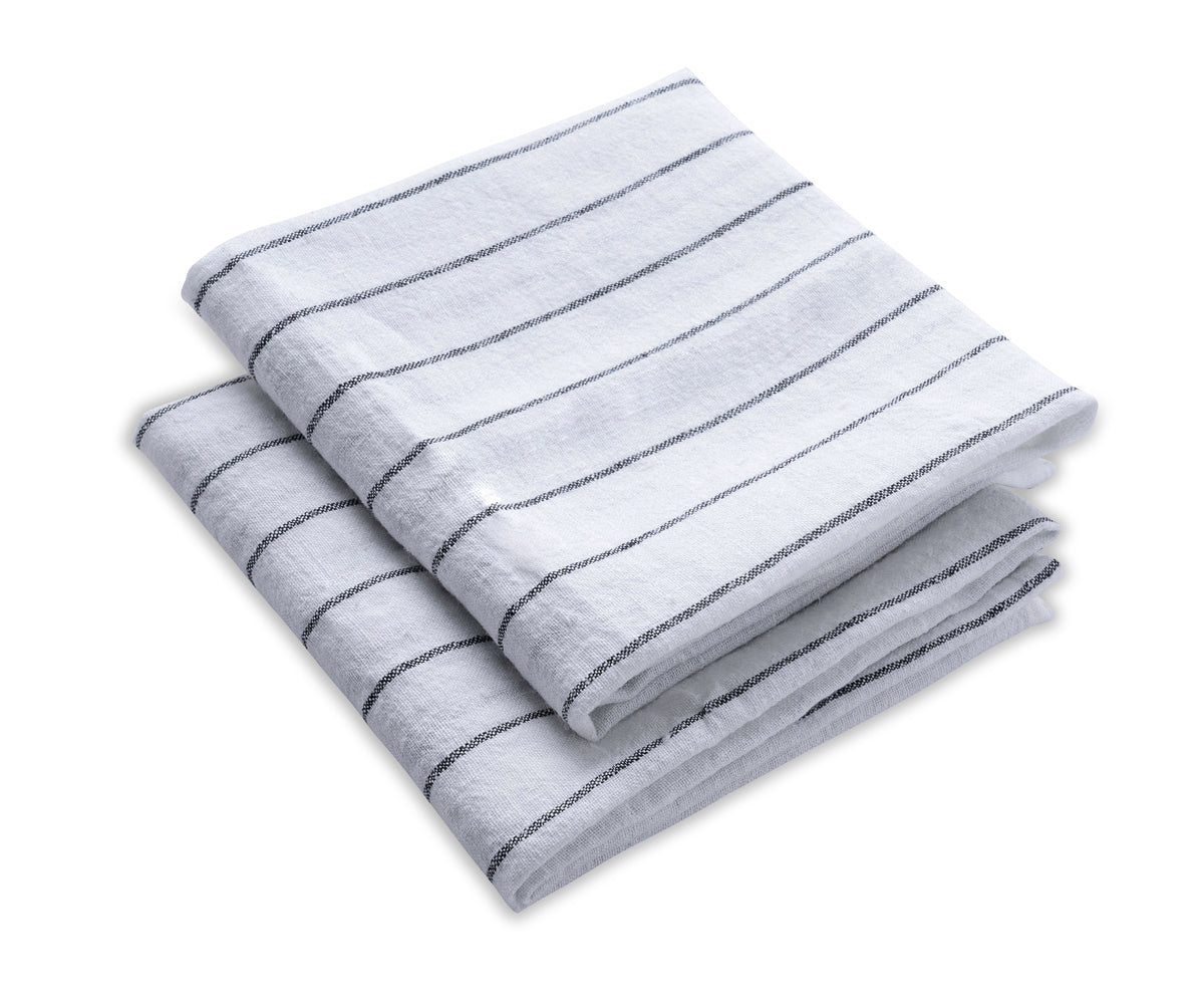 Rolled-up linen tea towel on a kitchen shelf. Ready for use, it adds a tidy and organized look.