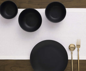 Minimalist white dining table runner styled with linen napkins and kitchen placemats