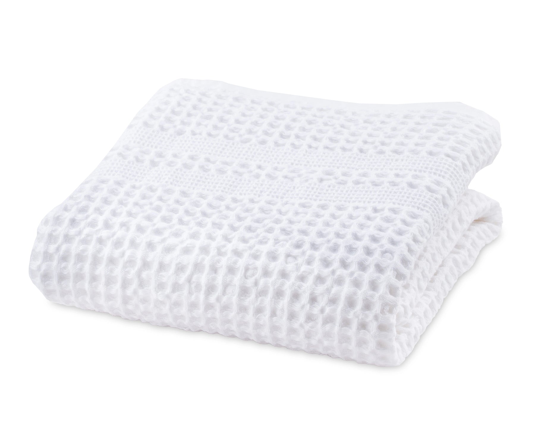White cotton waffle blanket neatly folded on a bed for a cozy look.