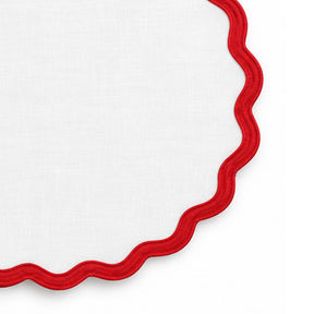 White cotton dining placemat featuring a contrasting red scalloped border,