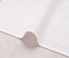 Single white cotton-linen blend napkin folded elegantly to show hemstitched edge