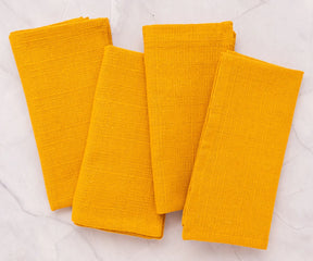 Set of soft yellow fabric napkins arranged for a festive meal.