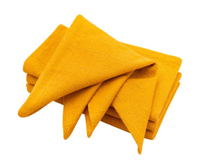 Elegant yellow table napkins displayed with seasonal centerpieces.