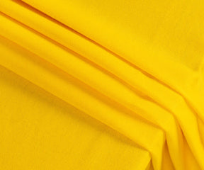 Yellow rectangle cotton tablecloth neatly spread on a wooden dining table, paired with rustic accents, showcasing a warm and inviting tablescape.