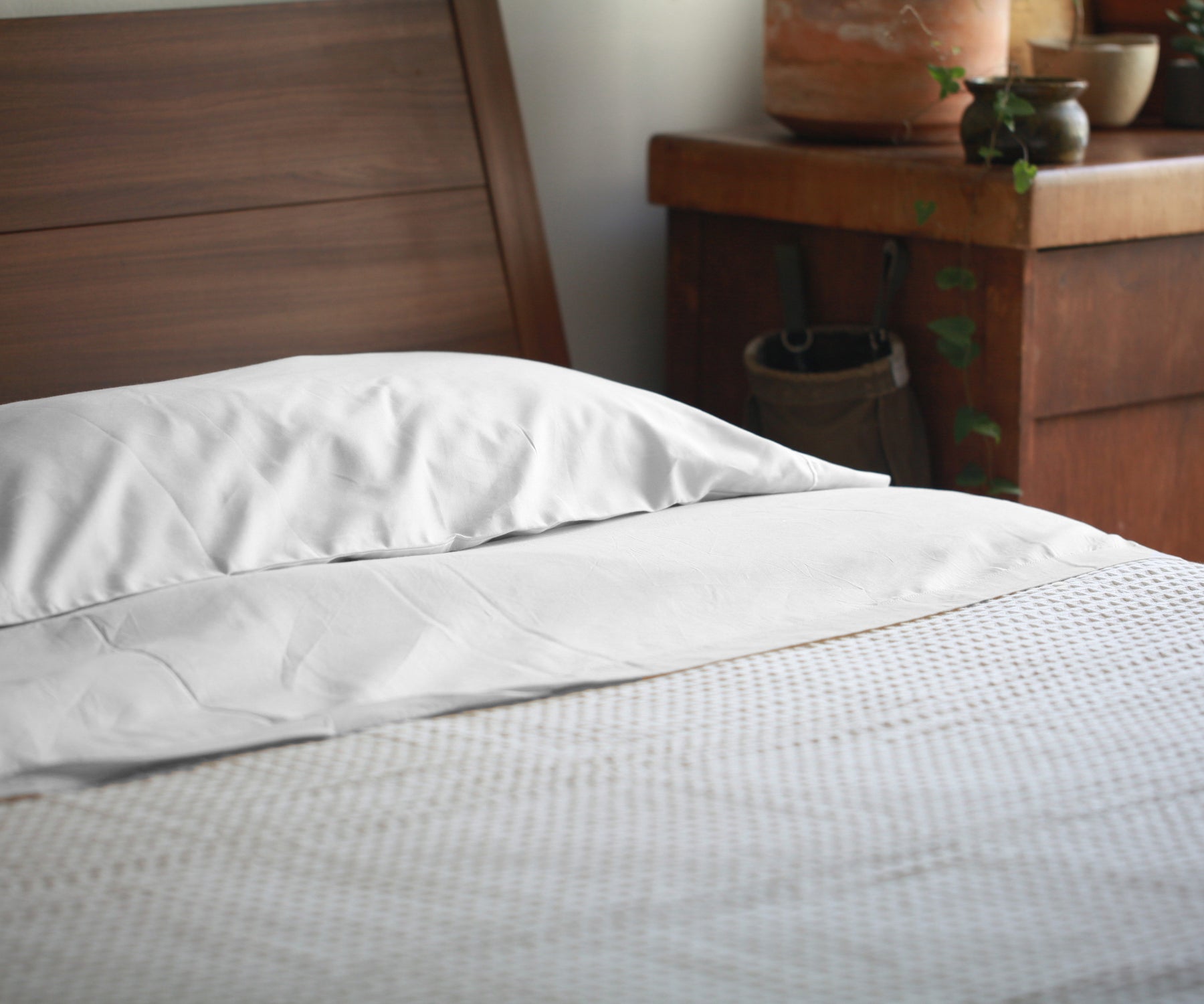 Bed covered with a white cotton fitted sheet