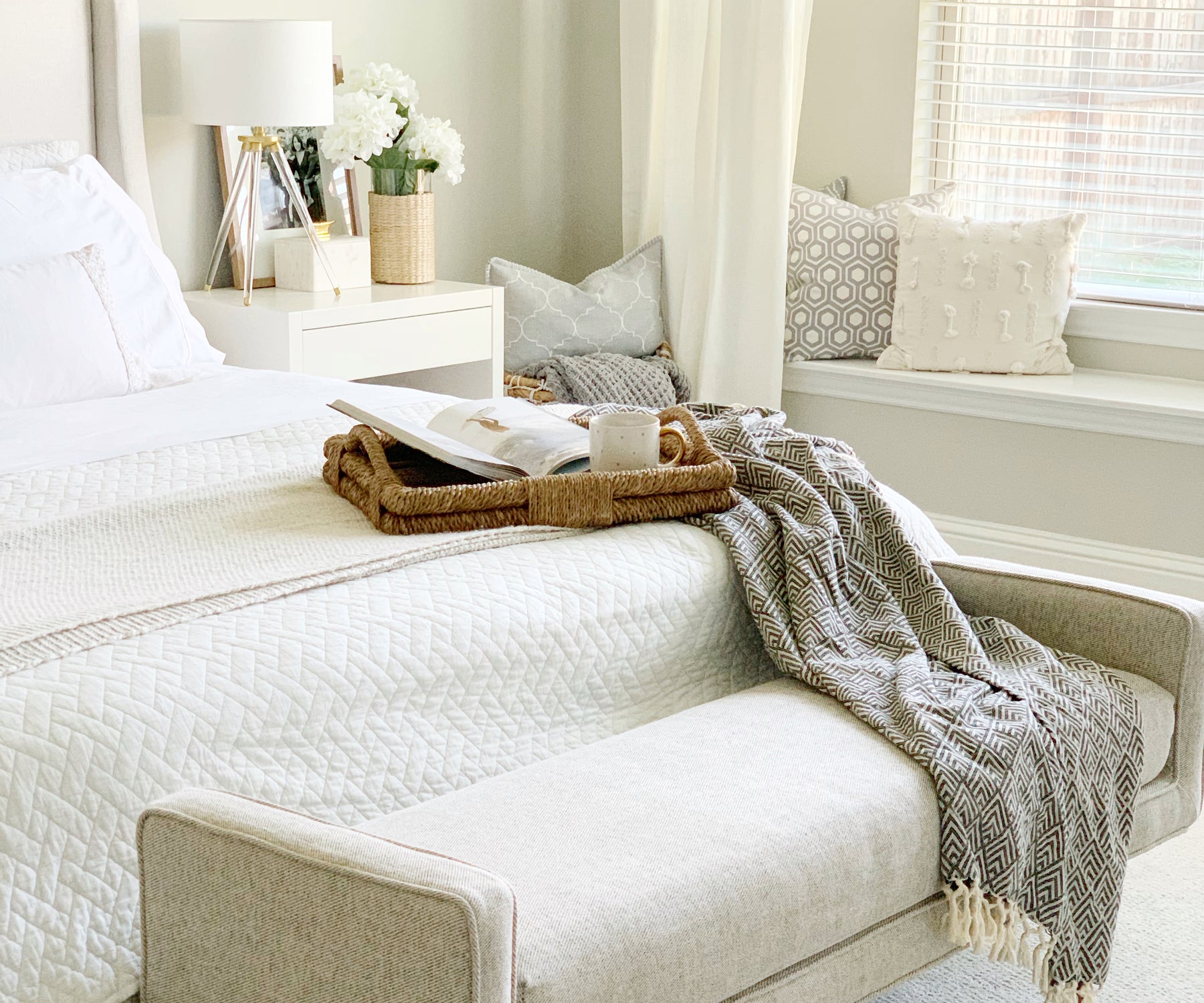 Bed adorned with white cotton fitted sheets and a matching blanket