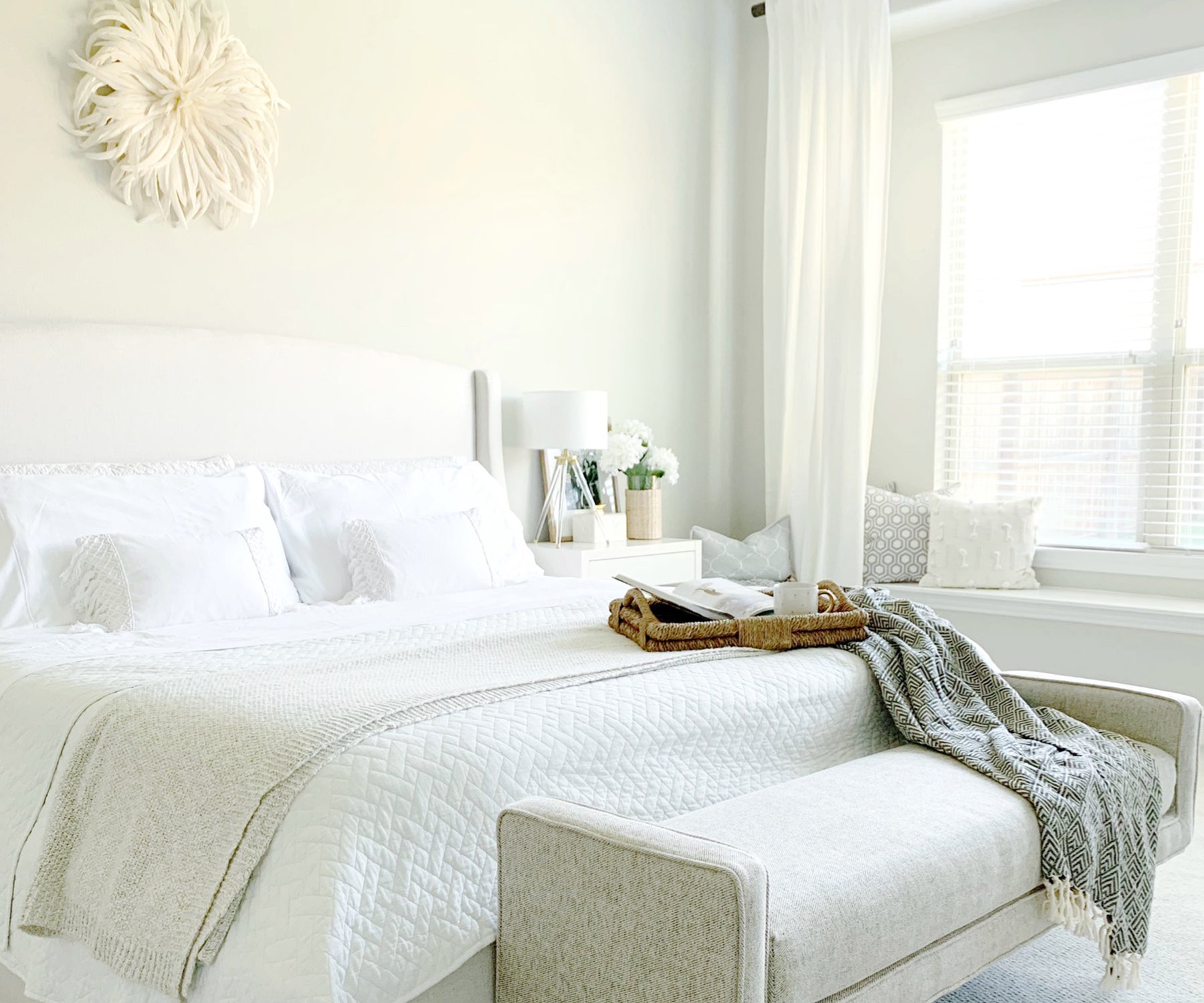 Neat bedroom featuring white cotton bedding and a matching chair