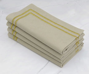 Beige cotton napkins with elegant gold border, folded set for dining table