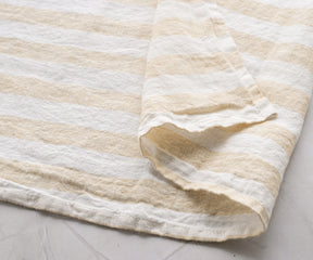 Beige and white striped linen kitchen towel with natural fabric texture close-up