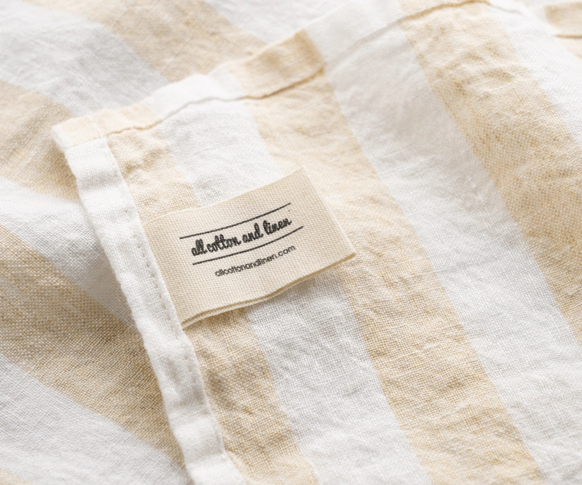 Beige striped linen towel with cotton label detail and natural fabric texture italian linen towels