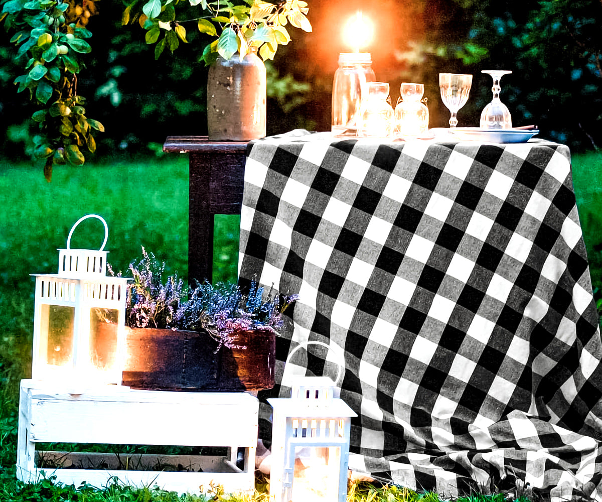 Black tablecloth with checkered pattern and decorative candles and lanterns